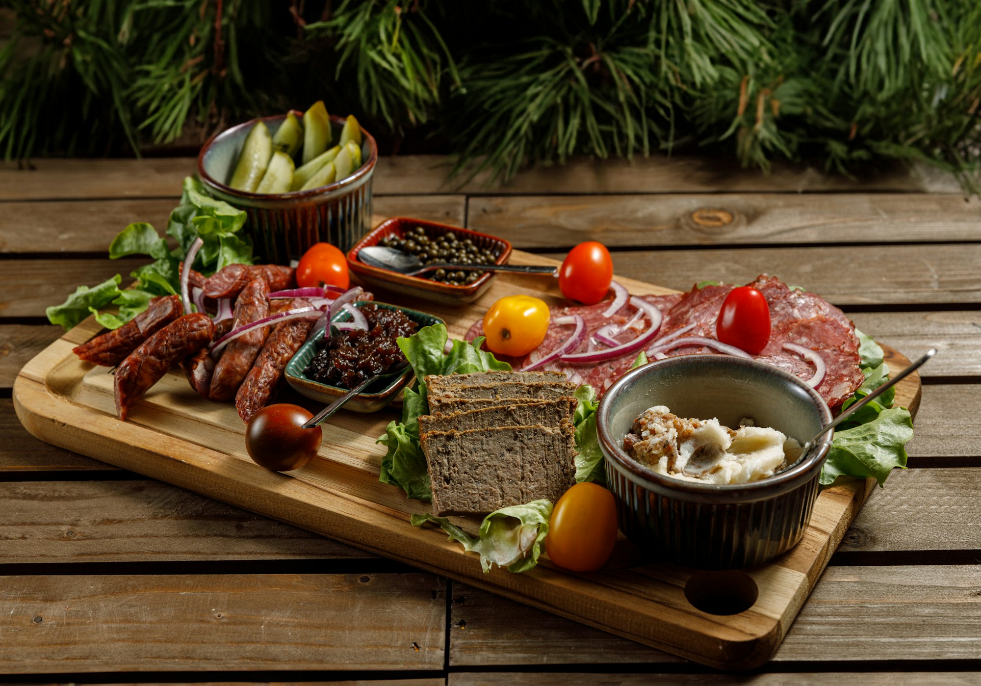 A beautiful artisanal charcuterie board arranged with pickles and fresh vegetables